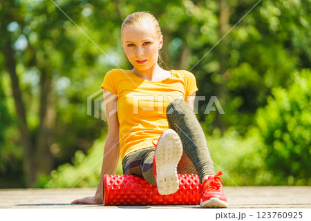 Girl doing exercises outdoor, using roller 123760925