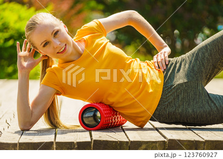 Girl doing exercises outdoor, using roller 123760927