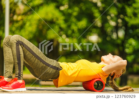 Girl doing exercises outdoor, using roller 123760929