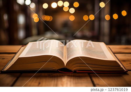 open antique book on wooden table with glitter overlay. 123761019