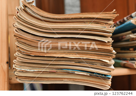 Stack of worn tattered antique newspapers or magazine in a vintage shop 123762244