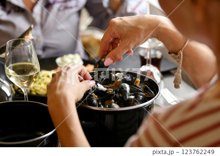 Woman's hands holding mussels over a pan of mussels in a fish restaurant 123762249