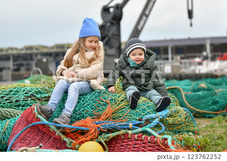 Brother and sister playing with fishing nets 123762252