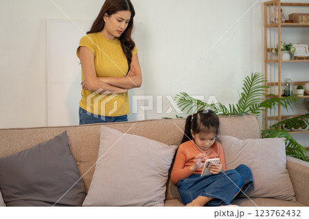Lovely mom and little young daughter spending time together in their living room. 123762432