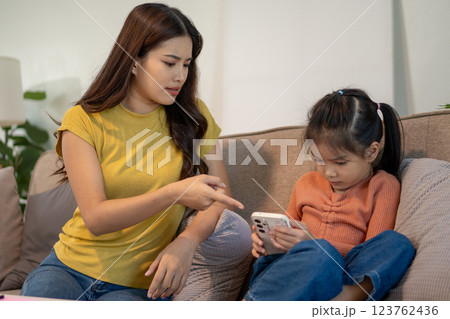 Lovely mom and little young daughter spending time together in their living room. 123762436