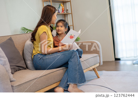 Lovely mom and little young daughter spending time together in their living room. 123762444