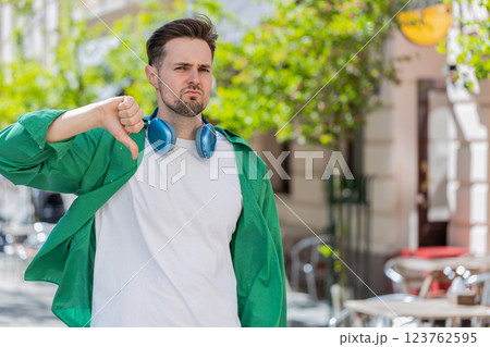 Man showing thumbs down sign dislike expressing discontent disapproval dissatisfied bad work mistake Man showing thumbs down sign dislike expressing discontent disapproval dissatisfied bad work mistake 123762595