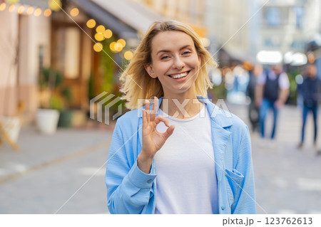 Young woman looking approvingly at camera showing OK gesture positive like sign Okay celebrate win Young woman looking approvingly at camera showing OK gesture positive like sign Okay celebrate win 123762613
