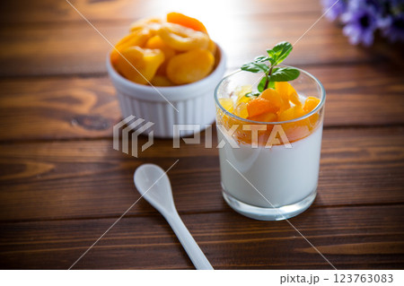 Light fruit yogurt with dried apricots on dark wooden table 123763083