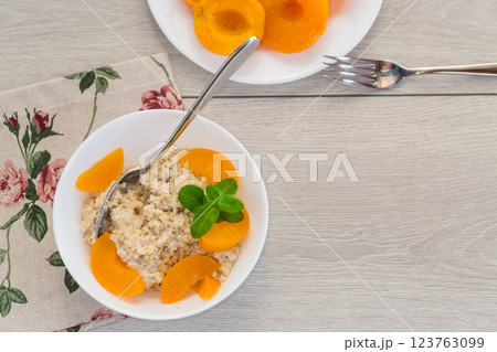 Nutritious milk porridge with pieces of sweet peaches Nutritious milk porridge with pieces of sweet peaches 123763099