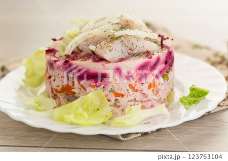layered vegetable salad with beets and herring, on a wooden table 123763104