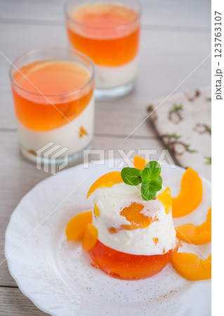 Layered fruit dessert with jelly, cream and fresh mint on a wooden table 123763107