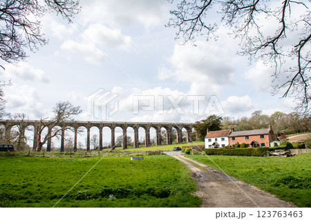 レンガ造りの歴史的な高架橋とレンガ造りの歴史的な家屋　ロンドンから南の郊外にあるオウズ渓谷にて 123763463