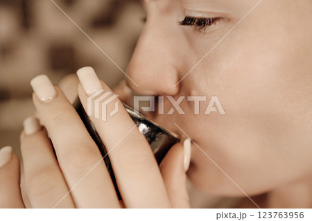 Woman Tea Drinking Cup Cozy Home Relaxation: Close-up image showing a woman enjoying a warm beverage indoors. Woman Tea Drinking Cup Cozy Home Relaxation: Close-up image showing a woman enjoying a warm beverage indoors. 123763956