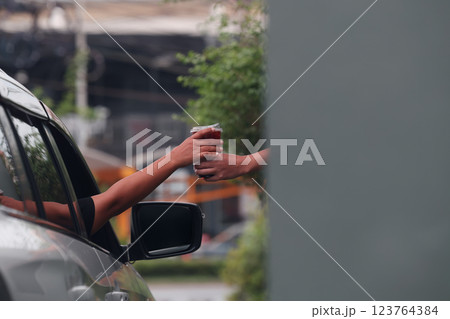 Hand Man in car receiving coffee in drive thru fast food restaurant. 123764384