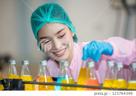 Worker Checking quality or checking stock of glass bottle in beverage factory 123764399