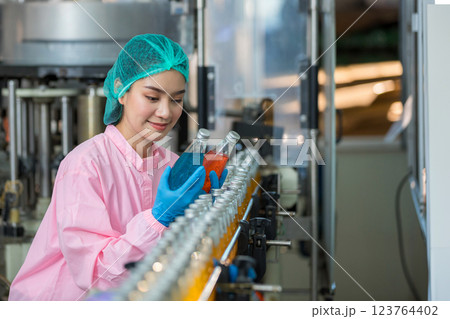 Worker Checking quality or checking stock of glass bottle in beverage factory 123764402