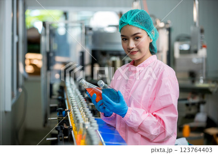 Worker Checking quality or checking stock of glass bottle in beverage factory 123764403