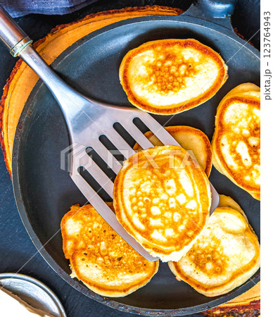 Small pancakes in a pan on a wooden board Small pancakes in a pan on a wooden board 123764943