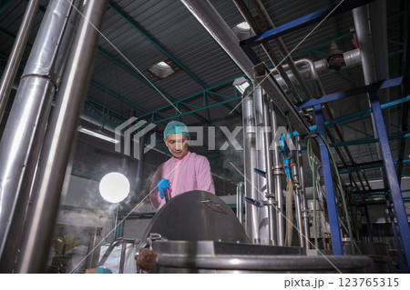 Worker Checking quality or checking stock of glass bottle in beverage factory Worker Checking quality or checking stock of glass bottle in beverage factory 123765315