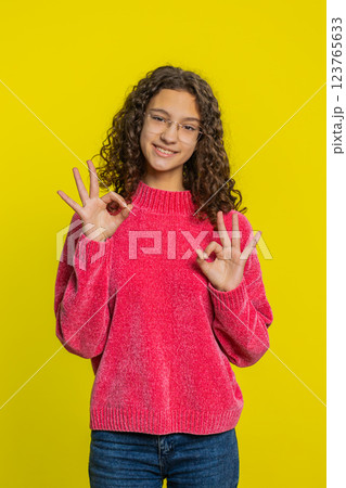 Happy teen girl showing ok gesture, like sign positive feedback, celebrate victory, approve idea 123765633