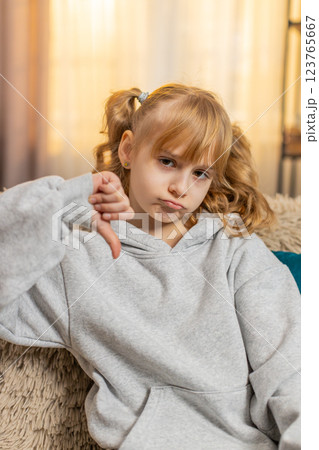 Young teenager girl showing thumbs down unhappy expression expressing disagreement indoors at home Young teenager girl showing thumbs down unhappy expression expressing disagreement indoors at home 123765667
