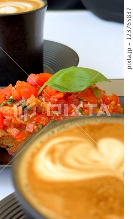 Bruschetta showcasing Mediterranean produce paired with coffee reflects seasonal eco-conscious farming practices and the region's culinary simplicity. Natural bruschetta coffee pairing. 123765837