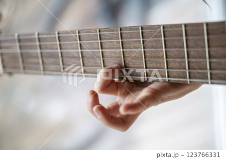 Child learning guitar chords 123766331