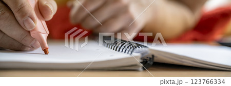 Closeup of hand highlighting notes in a spiral notebook 123766334