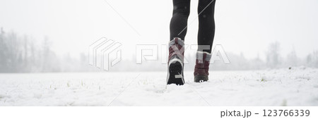 Female legs in winter boots walking in snow covered nature Female legs in winter boots walking in snow covered nature 123766339