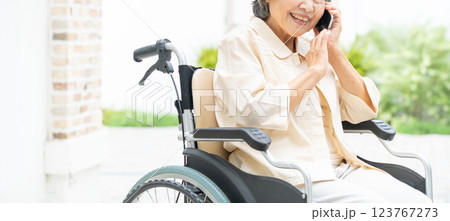スマートフォンで通話する車椅子のシニア女性 123767273