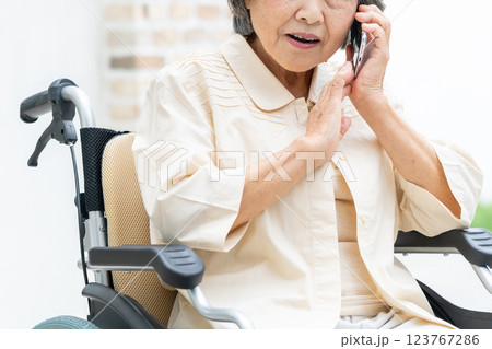 スマホで電話をする車椅子のシニア女性 123767286