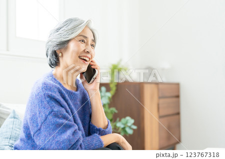 スマートフォンで通話するシニア女性 スマートフォンで通話するシニア女性 123767318