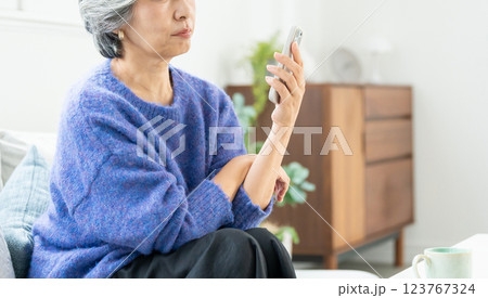 スマートフォンを操作するシニア女性 123767324