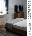 Serene bedroom featuring a neatly made bed, a wooden dresser, and a television. Concept of tranquility and comfort, importance of personal space and restful environments in daily life 123767606