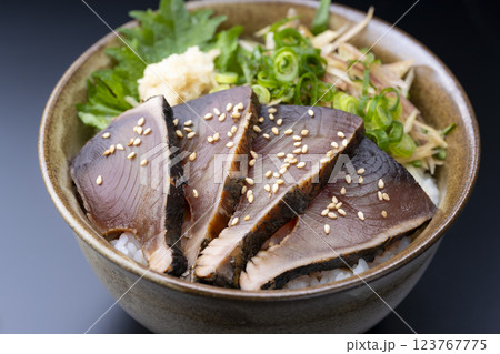 黒背景にたっぷり薬味を添えたカツオのたたき丼 123767775