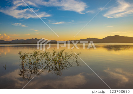 Landscape of mountains and lake at sunset and clouds reflected in the water. Landscape of mountains and lake at sunset and clouds reflected in the water. 123768650