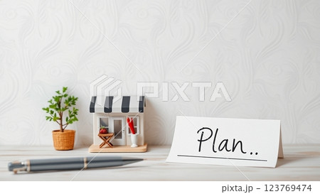 ミニチュアのお店と「PLAN」と書かれた紙とペン-開業計画 123769474