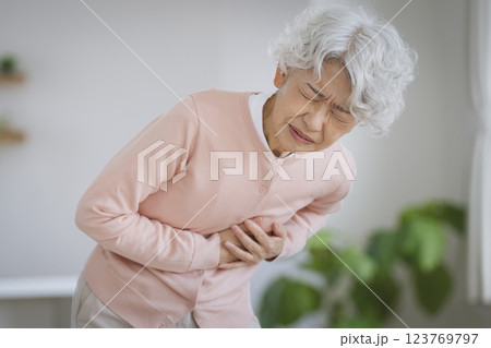 左胸をおさえて苦しむシニア女性 左胸をおさえて苦しむシニア女性 123769797