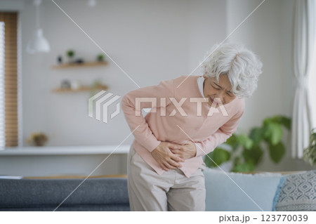 下腹部をおさえて苦しむシニア女性 123770039