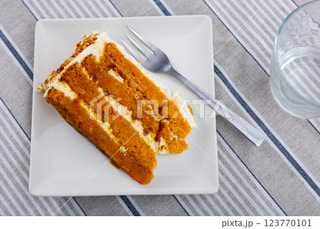 Small triangular piece of carrot cake is on plate Small triangular piece of carrot cake is on plate 123770101