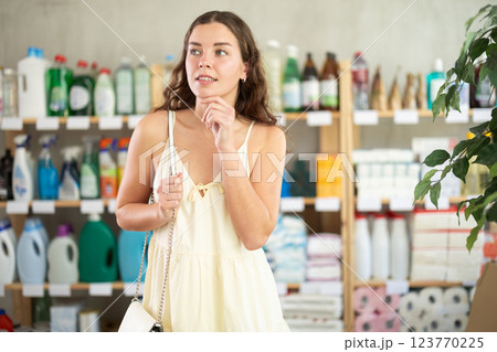 Young woman chooses household chemicals in store 123770225