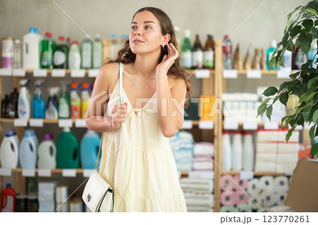 Young woman chooses household chemicals in store 123770261