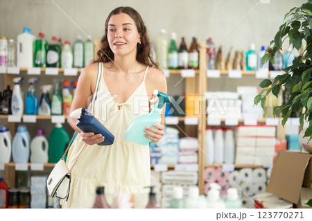 Young woman chooses cleaning spray in store 123770271