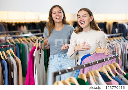 Two happy female friends are shopping in clothing store. Shopping young ladies 123770416