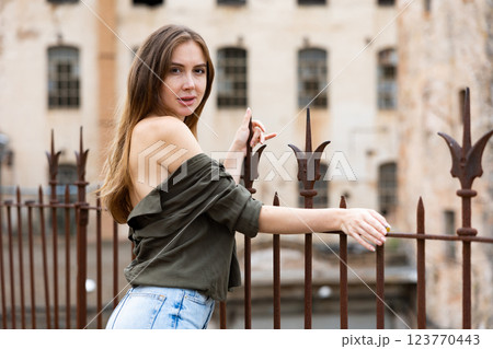 Outdoor fashion - beautiful blonde woman posing near wrought iron fence Outdoor fashion - beautiful blonde woman posing near wrought iron fence 123770443