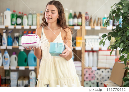 Girl in a summer dress chooses feminine pads in supermarket Girl in a summer dress chooses feminine pads in supermarket 123770452