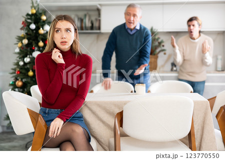 Father and husband scold young woman. Family quarrel during Christmas celebration 123770550