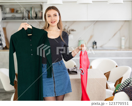 Young woman choosing which dress to wear 123770551