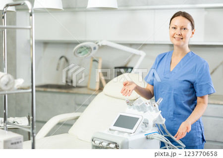 Adult woman cosmetologist posing with cosmetology apparatus Adult woman cosmetologist posing with cosmetology apparatus 123770658